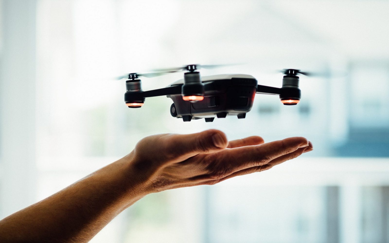 dose-media-DiTiYQx0mh4-unsplash A drone hovering over a person's hand.